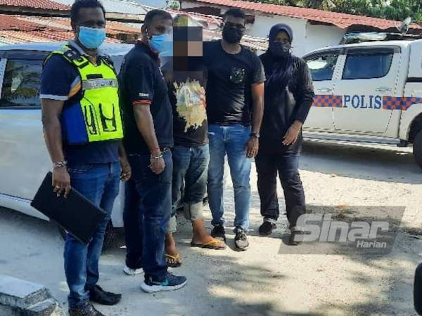 Suspek (tengah) ditahan untuk siasatan lanjut selepas melepaskan dua das tembakan dan mengugut mangsa pada Ahad.