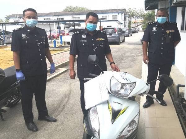 Agus (tengah) bersama pegawainya menunjukkan motosikal digunakan suspek untuk menjalankan kegiatan pengedaran dadah sekitar Sungai Besar pada sidang akhbar di IPD Sabak Bernam pada Isnin.