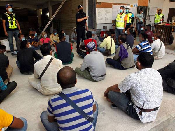 Noorzainy (berdiri tengah) sedang bertanya sesuatu kepada pekerja asing yang ditahan.