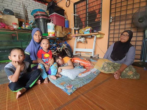 Siti Khalijah memangku dua anaknya manakala Norehan sedang membelai anak perempuannya yang merupakan OKU terlantar.