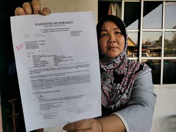 Abibah menunjukkan surat daripada peguam yang memintanya menjelaskan tunggakan pinjaman bank ketika ditemui Sinar Harian di Seremban pada Ahad.