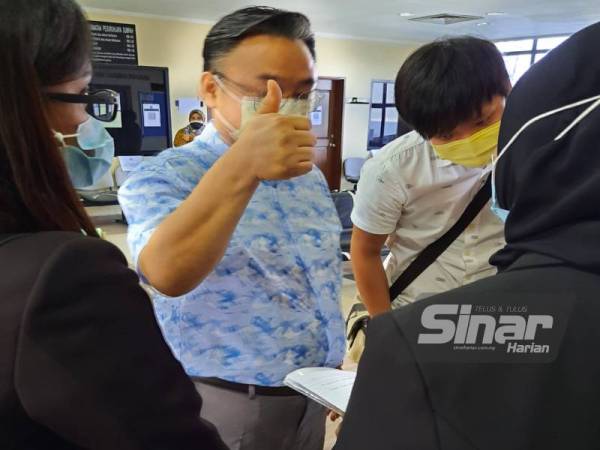 Tertuduh menunjukkan tanda bagus ketika media merakamkan gambarnya di mahkamah pada Selasa.