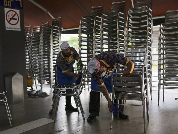 Para pekerja sebuah restoran nasi kandar dilihat mula melakukan kerja-kerja pembersihan menggunakan cecair penyahkuman ketika tinjauan di premis tersebut, hari ini. 