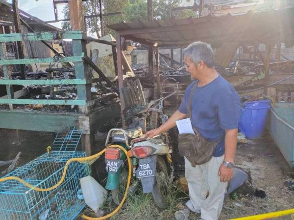 Matsu @ Mohd Johan melihat dua buah motosikalnya yang hangus dalam kejadian kebakaran di Jalan Masjid Kampung Merbau Patah, Kuala Terengganu pada Selasa.