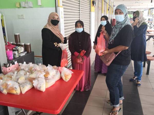 Nurhidayah memberikan mi kari percuma kepada pelanggan yang singgah di kedai makannya di Medan Selera MDSB Jalan Tebedu pada Ahad.