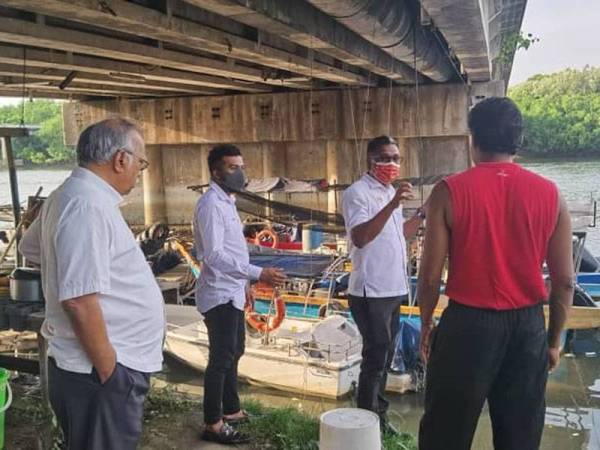 David (dua dari kanan) dan Ramasamy (kiri) ketika meninjau keadaan di Sungai Perai pada Selasa.