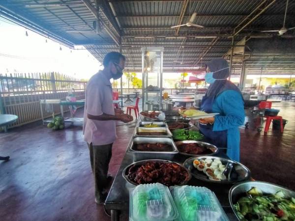 Rosliza (kanan) melayan pelanggan di restorannya di Simpang Empat, Alor Setar pada Rabu.