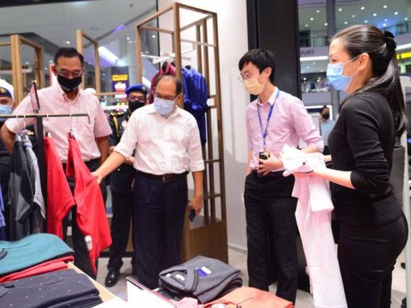 Hasnol Zam Zam (tiga dari kanan) melakukan tinjauan di premis pakaian di IOI Mall Puchong bersama Rosol (kiri).