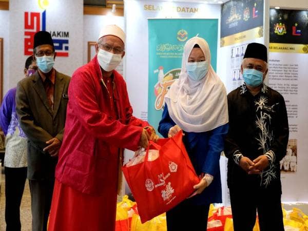Menteri di Jabatan Perdana Menteri (Hal Ehwal Agama) Datuk Seri Dr Zulkifli Mohamad Al-Bakri (tiga, kanan) menyampaikan sumbangan kepada Sharifah Noor Abdullah (dua, kanan) pada Majlis Sumbangan sempena Tahun Baru Cina 2021 kepada Mualaf anjuran (MAIWP) di Kompleks Islam Putrajaya hari ini. - Foto Bernama