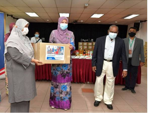 Menteri Pembangunan Wanita, Keluarga dan Masyarakat Datuk Seri Rina Harun (tengah) menyampaikan sumbangan kepada Orang Kurang Upaya (OKU) Penglihatan Rohaya Lias (dua, kiri) pada majlis penyampaian sumbangan bakul makanan di Kompleks Persatuan Bagi Orang Buta Malaysia (MAB) Bangsar hari ini. Foto BERNAMA
