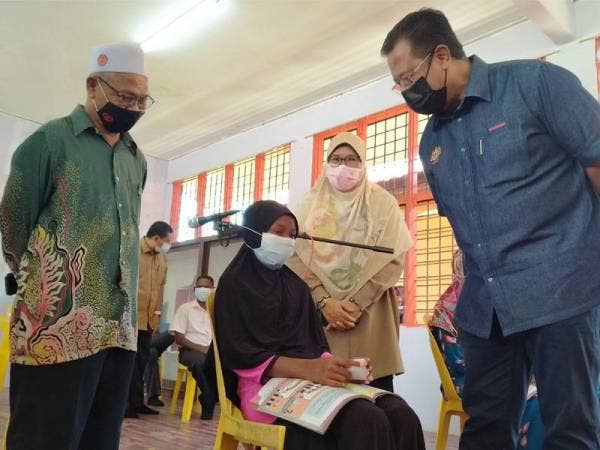Abdul Rahman (kanan) beramah mesra dengan Anis Suraya Roslan,12, dari Suku Kaum Kensui yang mengikuti PdPR di Kampung Lubuk Legong, Baling pada Khamis.