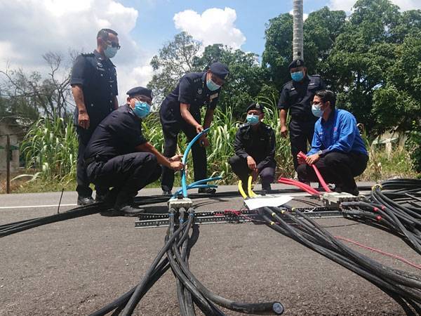 Shahrul Lalli (kiri) menunjukkan wayer dan kabel haram yang dirampas dalam sebuah premis di Pulau Sebang, Alor Gajah pada Rabu.