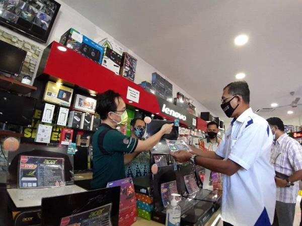 Rosol (kanan) mendengar penerangan daripada salah seorang penjual semasa melakukan lawatan dan pemeriksaan di sebuah pusat penjualan dan servis komputer di Panji Curve, di sini Khamis.