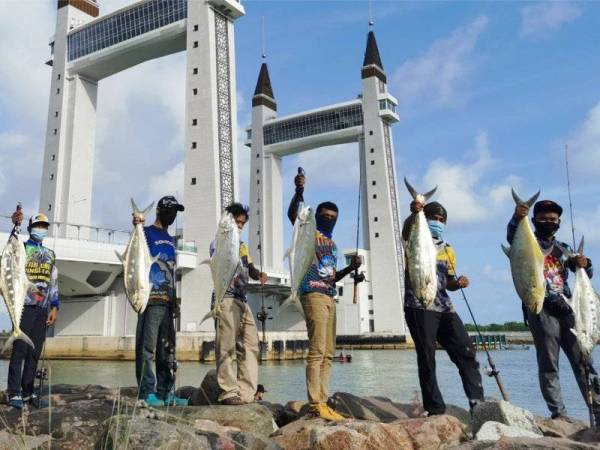 Sebahagian pemancing bersama hasil tangkapan diperoleh di kawasan muara sungai Terengganu berhampiran jambatan angkat di Kuala Terengganu pada Jumaat.