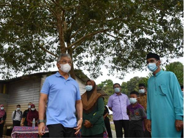 Al-Sultan Abdullah (kiri) berkenan beramah mesra dengan rakyat jelata ketika berangkat melihat proses pembinaan rumah baharu kepada mangsa banjir di Kampung Ganchong hari ini. - Foto Bernama