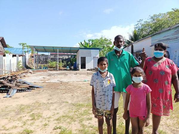 Ramachandra bersama isteri dan dua anaknya di hadapan tapak rumah yang telah dirobohkan bagi bina semula kediaman baharu yang dijangka siap Mac