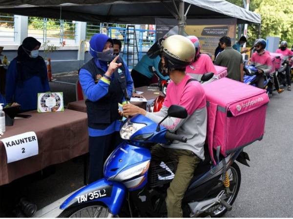 Farihah (tengah) memberi penerangan mengenai Skim Keselamatan Sosial Pekerjaan Sendiri (SKSPS) Perkeso kepada pekerja khidmat penghantaran yang melakukan pendaftaran di Wisma Perkeso pada Ahad.
-- fotoBERNAMA