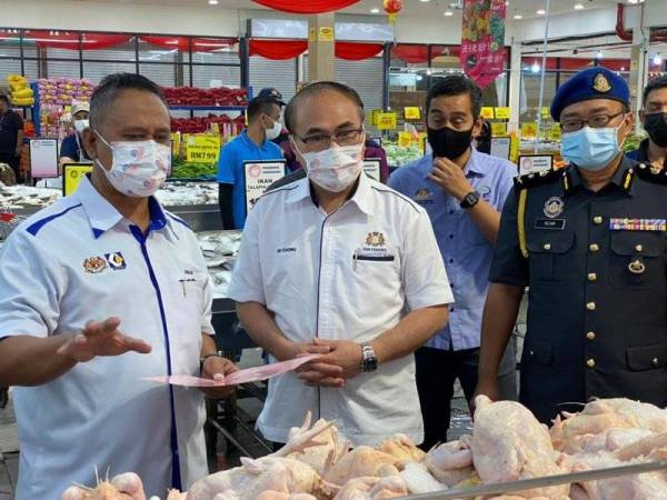 Fat Full (tengah) menyertai pemeriksaan sempena pelaksanaan Skim Harga Maksimum Musim Perayaan Tahun Baharu Cina di Pasaraya SongMart, Kluang pada Isnin.