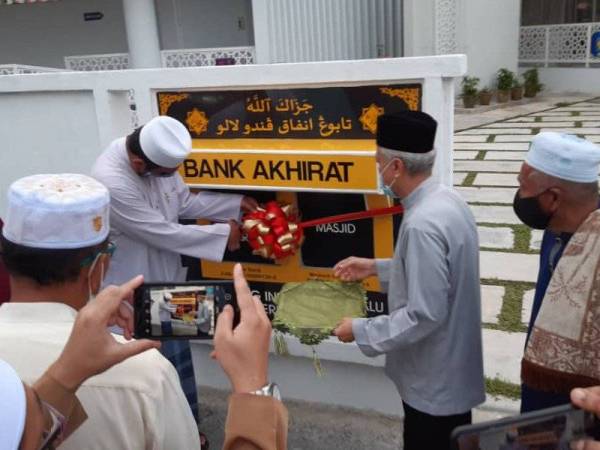 Syed Ibrahim (kiri) merasmikan tabung infaq pandu lalu atau ‘Bank Akhirat’ di Masjid Kampung Baru, Bentong, Khamis lalu.
