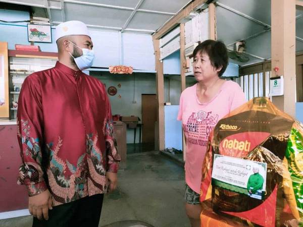 Mohd Tarmizi (kiri) menyantuni masyarakat Tionghua dan menyampaikan sumbangan berupa hamper kepada peniaga di sekitar Taman Tas.