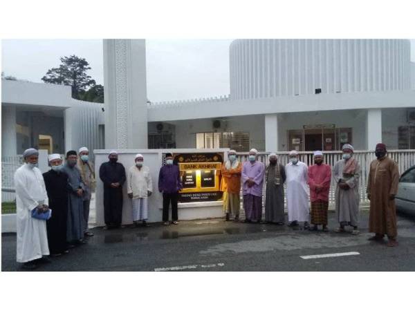 Zainal (empat, tengah dari kanan) dan Mat Nawi (kiri) bersama AJK Masjid Kampung Baru bergambar dengan tabung infaq pandu lalu di hadapan masjid.