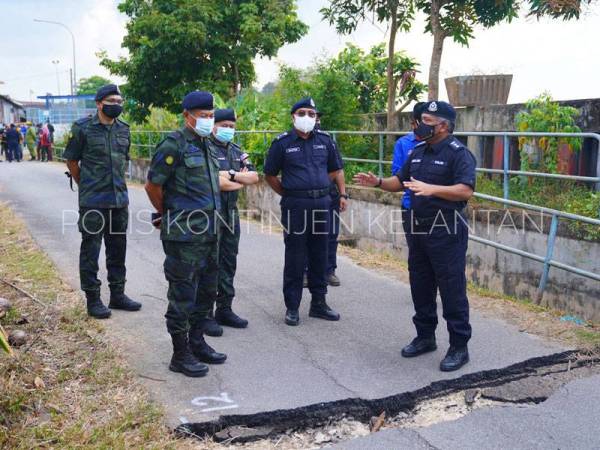 Abd Rahim (kiri) bersama Shafien (dua dari kanan) semasa meninjau situasi terkini kejadian runtuhan tebing Sungai Kelantan di Kampung Pohon Chelagi, Pasir Mas.