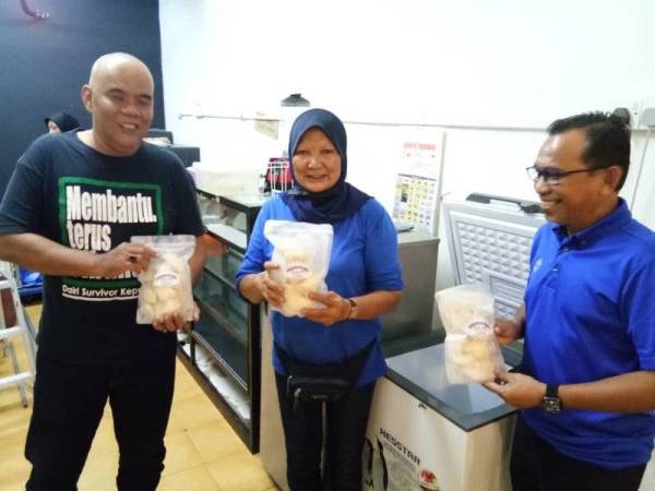 Pakar Motivasi Harun Abu Bakar@ Cgu Jinggo (kanan) melihat produk karipap sejuk beku yang diusahakan Mak Wan.
