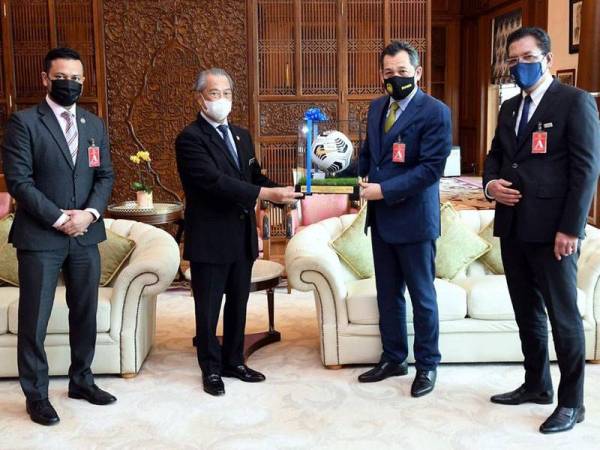 Hamidin (dua dari kanan) menyampaikan cenderahati kepada Muhyiddin di Putrajaya pada Khamis. - FOTO: FB FAM