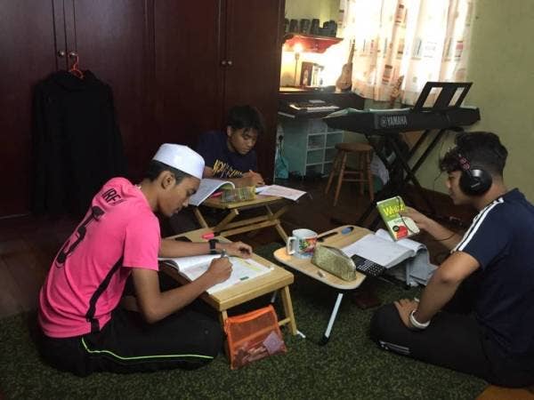 Ahmad Irfan (kiri) bersama dua rakan menjalani sesi pembelajaran secara berkumpulan sebagai persiapan menghadapi SPM tidak lama lagi.