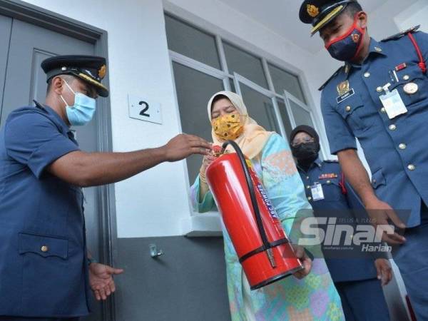 Zuraida (tengah) pada majlis penyerahan alat pemadam api di Taman Perumahan Rakyat Makmur, Gambang Jaya 2, Kuantan pada Sabtu.