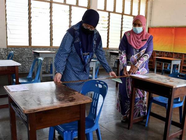Pengetua Sekolah Menengah Kebangsaan Tunku Puan Habsah, Farida Abdul Wahab (kanan) bersama penolong kanan Hal Ehwal Pelajar sekolah berkenaan, Mazidah Hashim menyusunkan meja mengikut prosedur operasi standard (SOP) yang ditetapkan oleh Majlis Keselamatan Negara (MKN) bagi pelajar-pelajar sekolah berkenaan menduduki peperiksaan SPM 2020 esok.