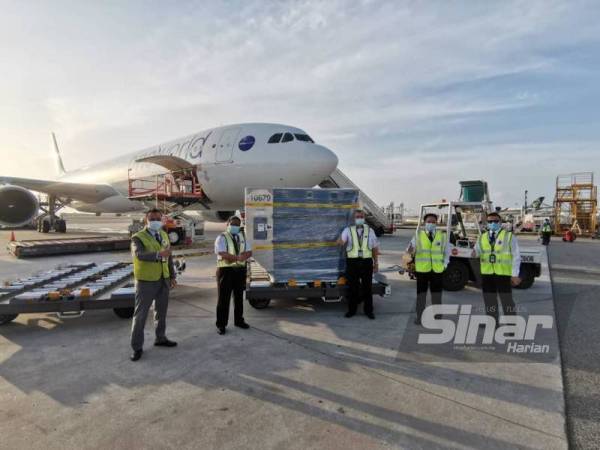 Hamdan (dua dari kanan) bersama pasukan di Lapangan Terbang Changi Singapura yang terbang julung kali membawa pulang vaksin Covid-19 ke Malaysia pada Ahad.- Foto Sinar Harian