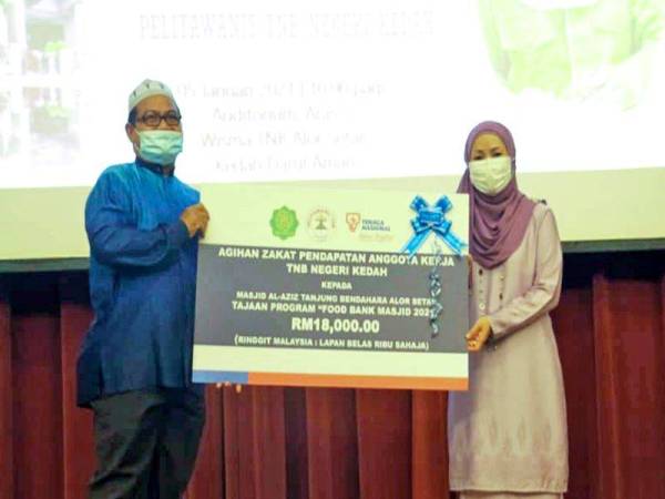 Yang Dipertua PELITAWANIS TNB Kebangsaan, Datin Seri Aidah Abu (kanan) menyampaikan replika cek sumbangan berjumlah RM18 ribu kepada Penolong Amil Masjid Al-Aziz Tanjung Bendahara, Sahimi Yaacob (kiri) semasa satu majlis penyerahan, tajaan Majlis FoodBank Masjid 2021 dengan kerjasama TNB Kedah, PELITAWANIS TNB Cawangan Alor Setar dan Lembaga Zakat Negeri Kedah di Alor Setar, 5 Januari 2021.