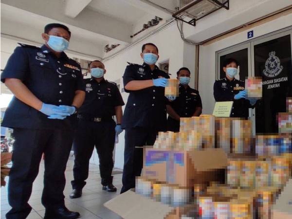 Nurulhuda (kanan) menunjukkan antara rampasan susu formula bayi susulan penahanan sepasang suami isteri, pada Jumaat lalu di Klang.