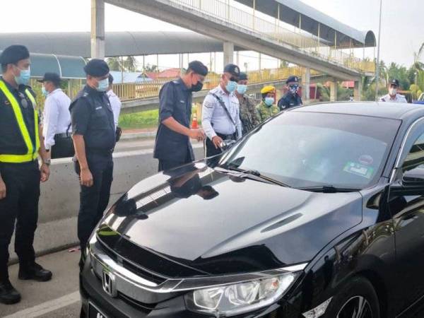 Azman (dua dari kanan) bersama Ketua Polis Daerah Sabak Bernam, Superintendan Agus Salim Mohd Alias melakukan pemeriksaan terhadap sebuah kereta di SJR Bagan Nira di Sabak Bernam pada Selasa.