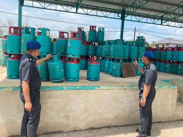 Anggota KPDNHEP Pasir Mas memeriksa tong LPG di sebuah kedai runcit yang menjual melebihi harga kawalan di Jalan Rantau Panjang.