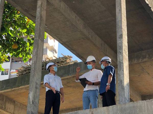 Tung Seang (kiri) mendengar penjelasan mengenai projek Pusat Transit Gelendangan di Pulau Pinang ketika melawat ke tapak projek berkenaan pada Selasa.