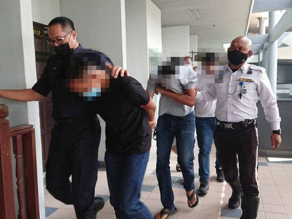 Azwan berbaju hitam bersama tiga pemandu lain dibawa keluar dari Mahkamah Majistret Ayer Keroh, pada Rabu selepas didakwa atas pertuduhan memandu secara berbahaya.