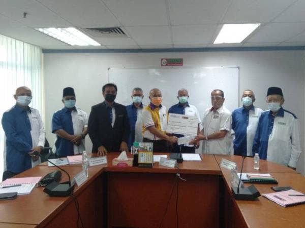 Abd Rahman (lima dari kiri) menyerahkan mok cek kepada Ali (tiga dari kiri) sebagai simbolik dalam majlis ringkas yang berlangsung di Ibu Pejabat PPNS, pada Khamis.