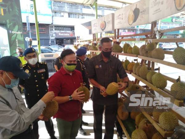 Rosol (kanan) memantau durian yang dipasarkan sekitar kawasan SS2 ketika tinjauan beliau pada Khamis.