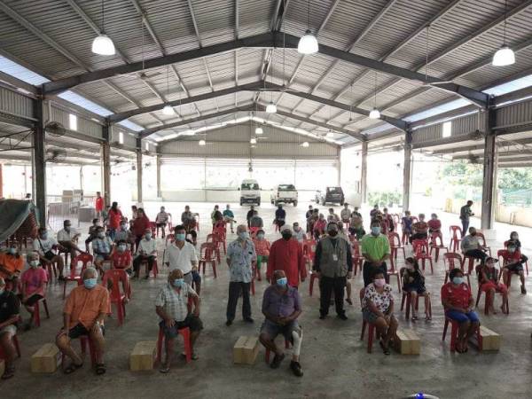 Nasrudin dan sukarelawan Yadim bersama penerima bantuan kotak makanan dalam kalangan masyarakat Tionghua di Tokong Sam Seng Kong, Gambang di sini pada Sabtu.