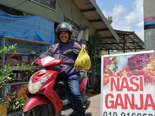 Mohd Faizal membuat penghantaran makanan kepada pelanggan yang menempah 'nasi ganja' yang diusahakannya.