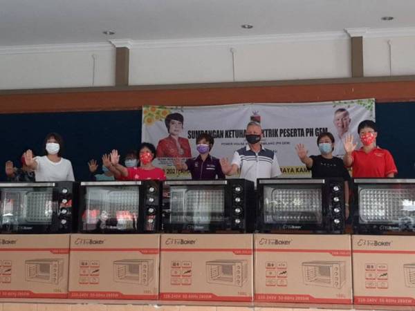 Nicole (tiga dari kiri) bersama peserta PH Gem yang menerima sumbangan ketuhar elektrik di Kampug Baru Mambai pada Ahad.