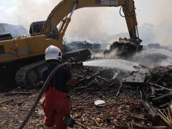 Jengkaut digunakan untuk mengasingkan sampah yang terbakar.