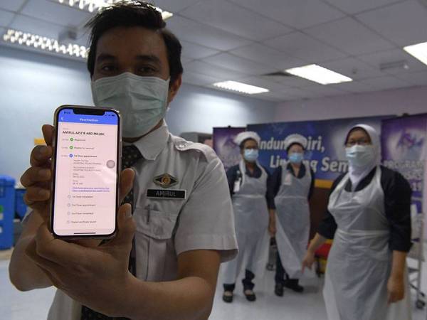 Penolong Pegawai Perubatan, Amirul Aziz Abd Malek menunjukkan aplikasi Mysejahtera yang memaparkan dos pertama suntikan vaksin Covid-19 dilaksanakan di Pusat Pemberian Vaksin Covid-19, Hospital Pulau Pinang (HPP) hari ini.