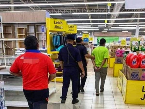 Gambar tular di Facebook menunjukkan lelaki berkenaan ditahan anggota polis selepas merakamkan video punggung wanita di sebuah pasar raya di Sungai Petani pada Ahad.