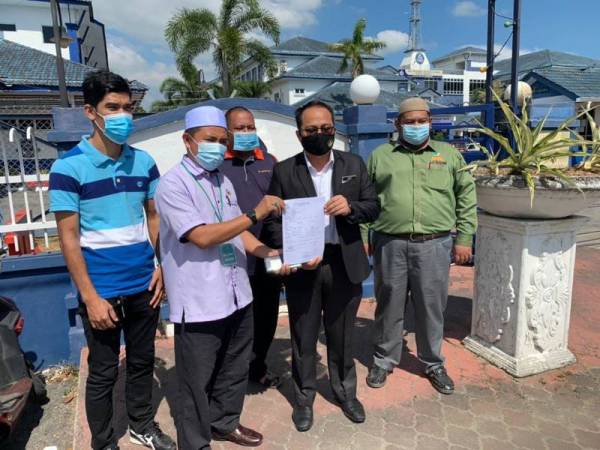 Taufik (dua dari kanan) menunjukkan laporan polis yang dibuatnya di IPD Kota Bharu pada Rabu.
