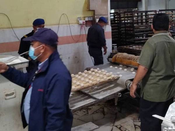 Anggota penguat kuasa KPDNHEP bersama JAIPk ketika melakukan serbuan ke sebuah kilang memproses makanan di Kawasan Perindustrian Ipoh pada Selasa.