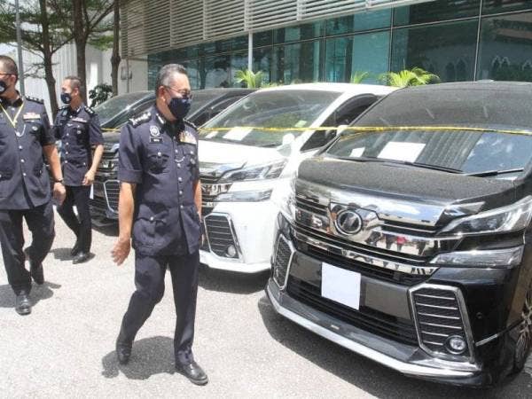 Saiful Azly (kanan) melihat kereta yang dirampas selepas sidang akhbar di Ibu Pejabat Polis Kontinjen (IPK) Kuala Lumpur pada Jumaat.