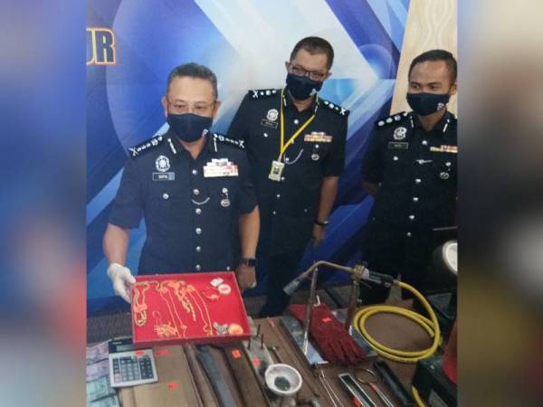 Saiful Azly (kiri) menunjukkan hasil rampasan pada sidang akhbar di Ibu Pejabat Polis Kontinjen Kuala Lumpur pada Jumaat.